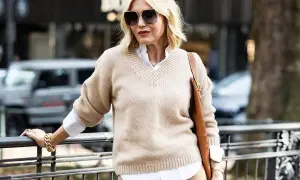Eleganckie zestawy ubrań dla 50-latki: beżowy sweter, biała koszula i brązowa torebka. Stylowa kobieta w modnej stylizacji.
