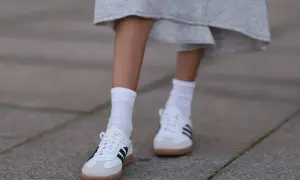 Białe Adidas Samba w stylizacjach z szarą spódnicą i białymi skarpetkami. Klasyka, która zawsze się obroni.