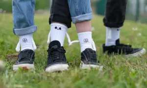 Zabawne skarpetki z postaciami, noszone na dżinsach, tworzą oryginalny sposób na noszenie skarpetek na spodniach.