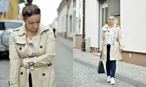 Kobieta w beżowym trenczu i sportowych stylizacjach, z torebką i okularami przeciwsłonecznymi, idzie po brukowanej ulicy.
