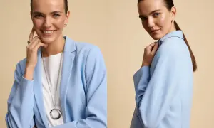 Kobieta w błękitnej marynarce, prezentująca monochromatyczny styl. Uśmiecha się, dotykając twarzy, a w drugiej części ujęcia odwraca się, ukazując elegancką biżuterię.