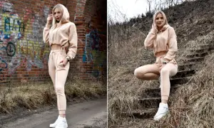 Blondynka w beżowym dresie pokazuje, jak nosić dresy na co dzień. Stylizacja z crop topem i sneakersami.