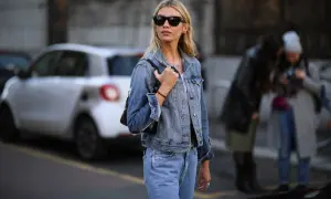 Kobieta w okularach przeciwsłonecznych i jeansowej kurtce, prezentująca modne kurtka jeansowa stylizacje.