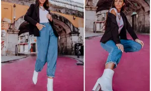 Eleganckie stylizacje z jeansami: kobieta w czarnym blazerze, białej koszulce i luźnych jeansach, uzupełnione białymi botkami na obcasie.