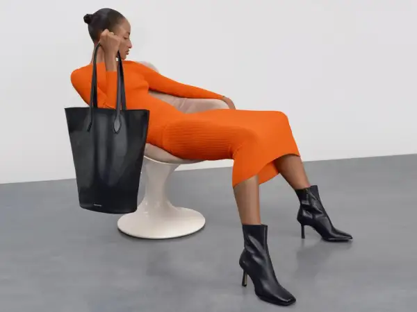 Eleganckie czarne botki i torebka do pomarańczowej sukienki. Idealne buty do sukienki na zimę.